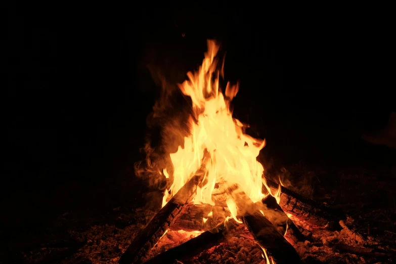 some logs and some fire burning in the dark