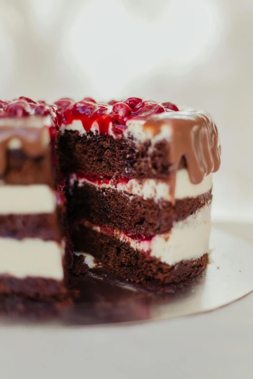 an uncut cake with white chocolate and raspberries