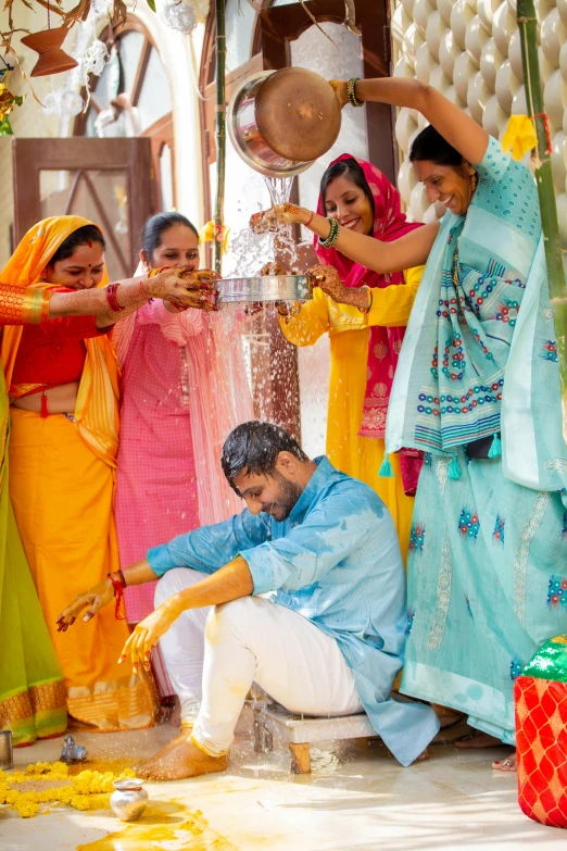 people dressed in sari posing for a pograph