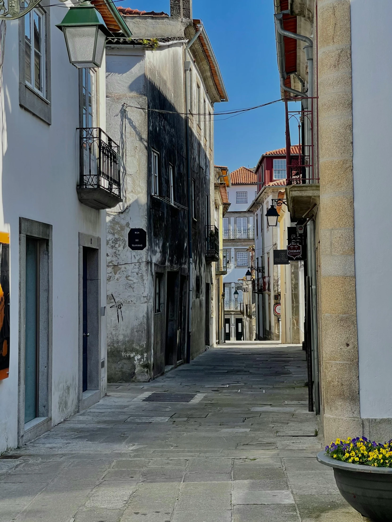 a narrow city street with an alley in the foreground and apartment buildings at the back