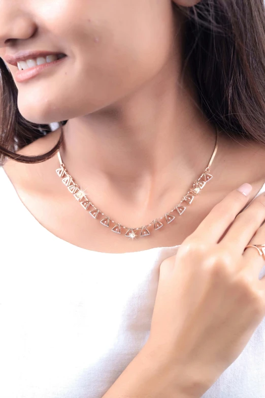 the neck and hand of a woman wearing a diamond necklace