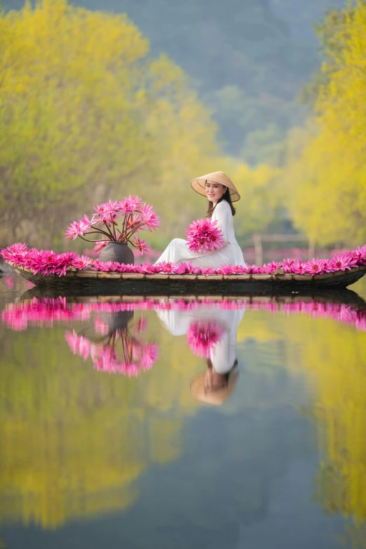 the woman is sitting in a boat full of flowers