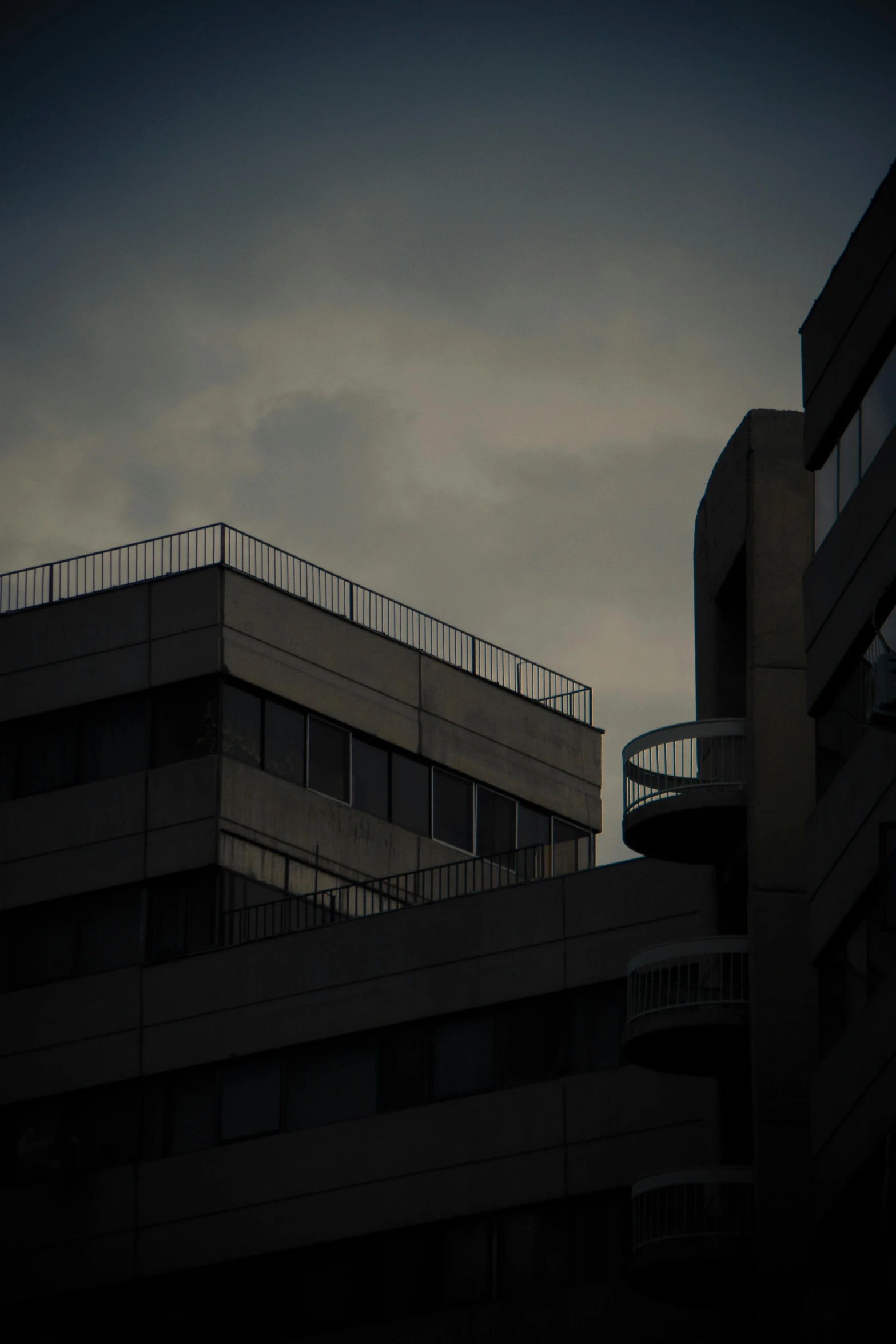 the top of a building with balconies against a dark sky