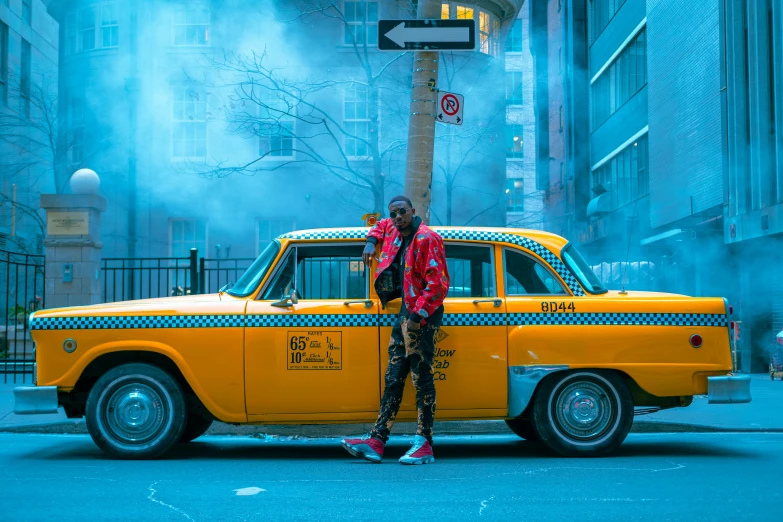 a man standing in front of a yellow taxi