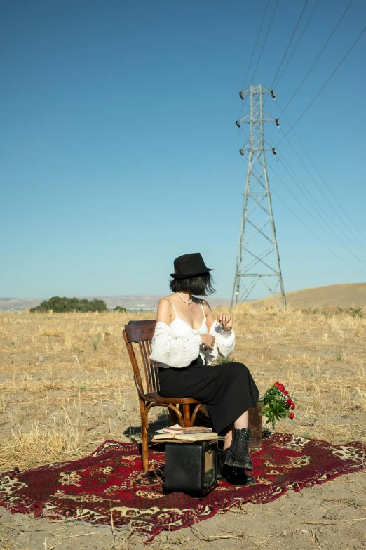 the woman sitting on the chair has a  beverage in her hand