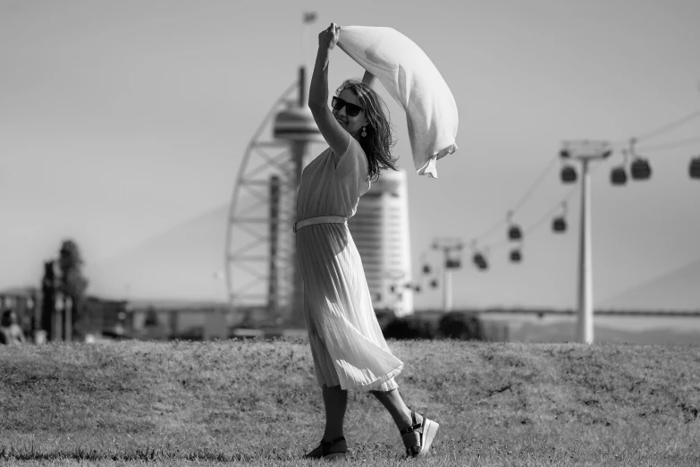 a woman standing in a field holding up an object