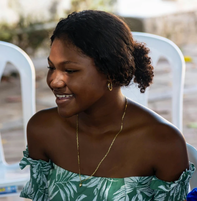 a woman is smiling in front of a white chair