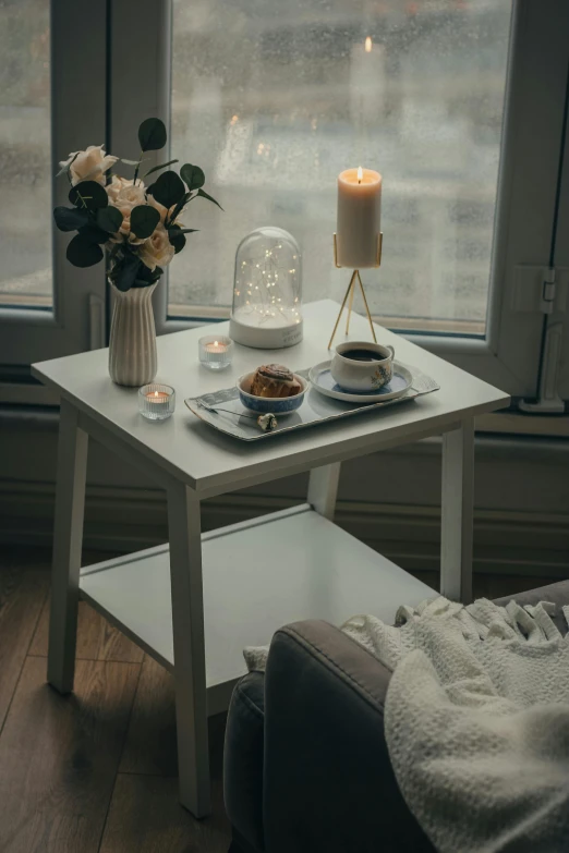 the white coffee table has flowers and two plates