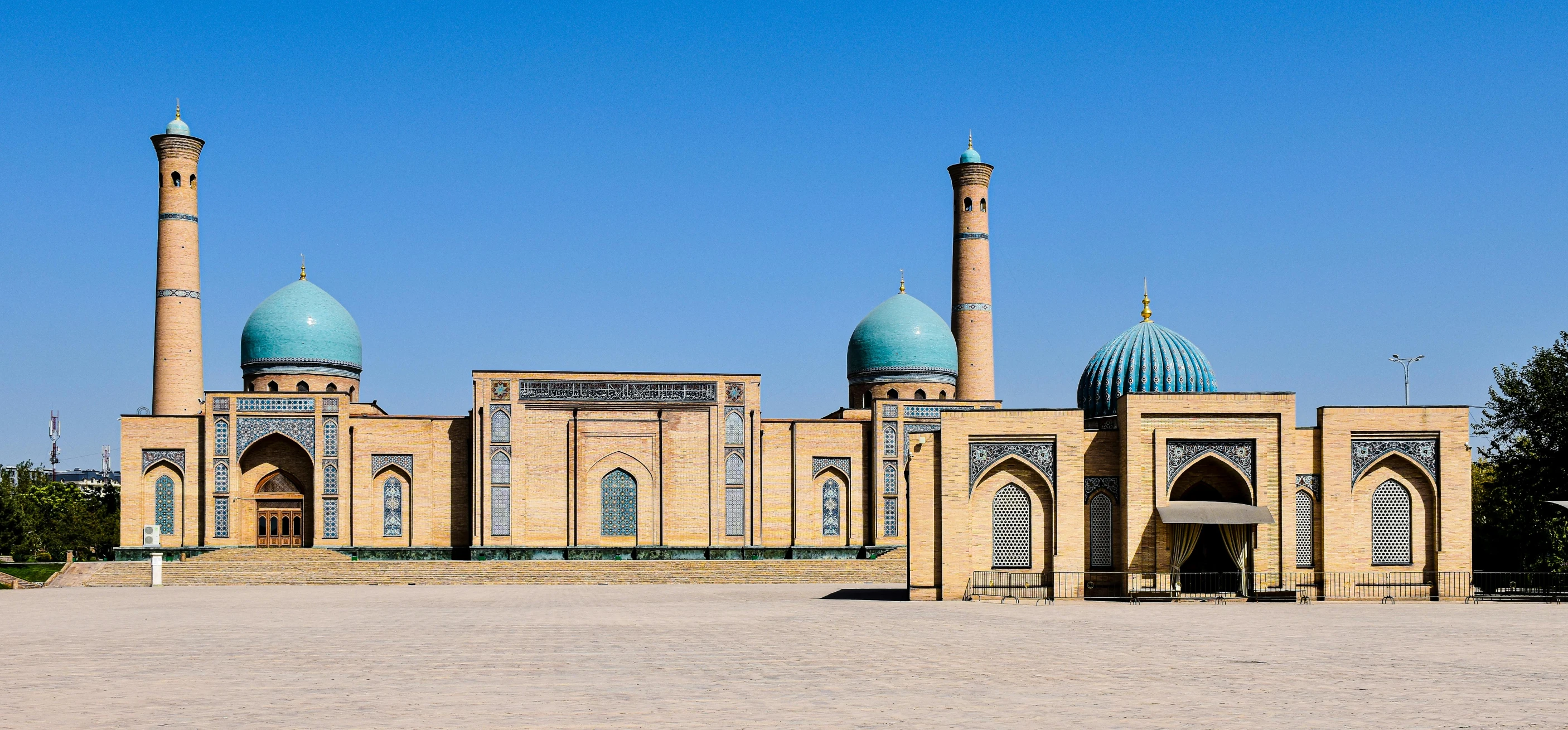 a large stone building with two large green domes