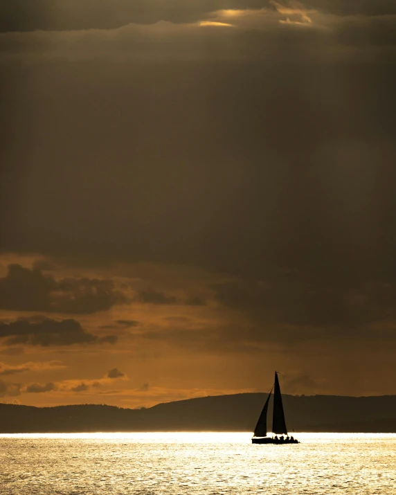 a boat floating in the ocean during sunset