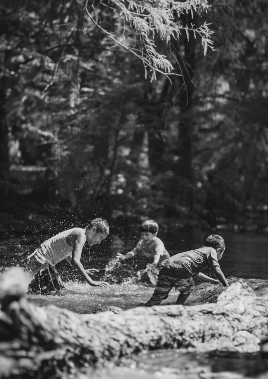 boys are in a creek playing in the water