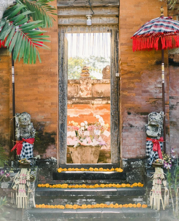 a display of flowers with an umbrella by a window