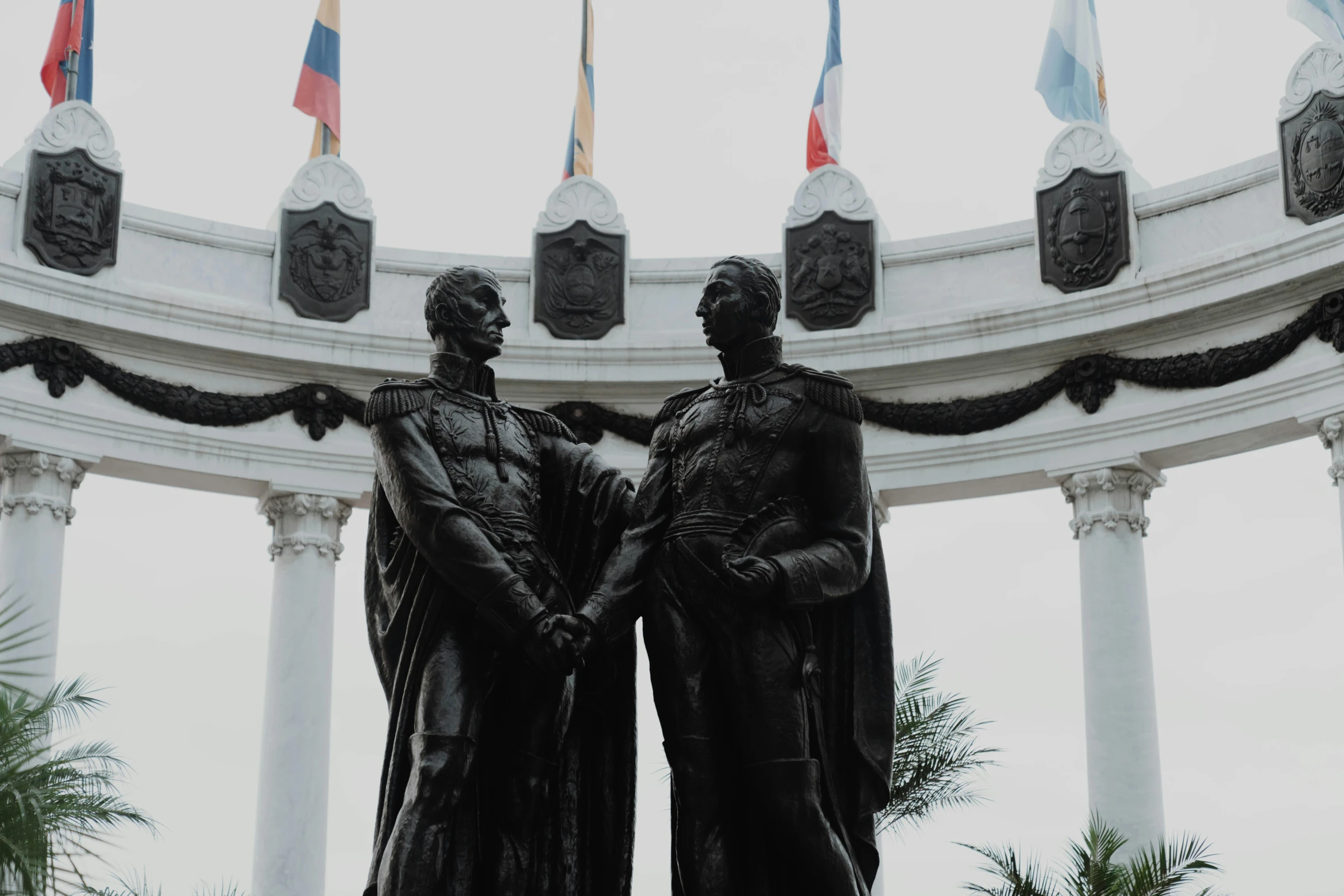 two men in the center of a monument with flags flying above