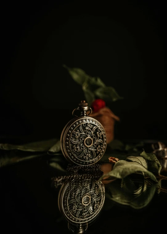 a rose and a pocket watch on a table