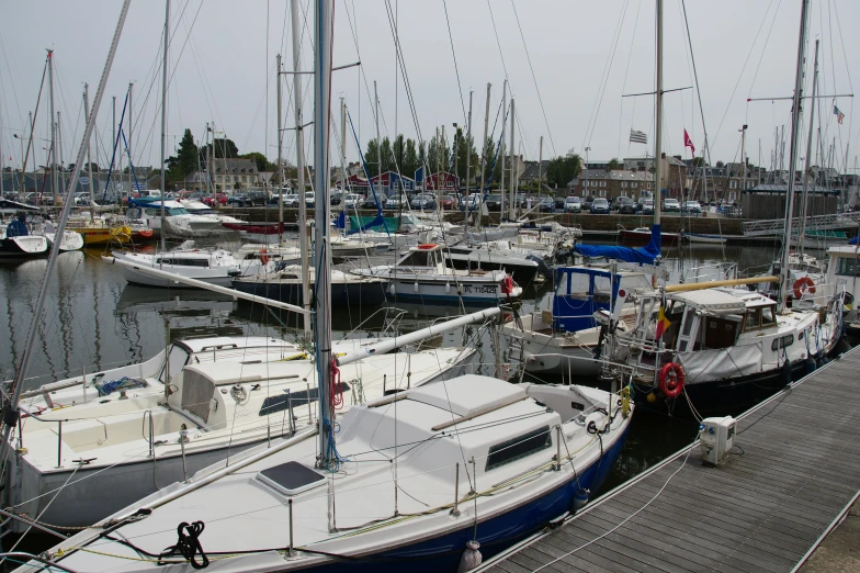 many sailboats are parked next to each other on the water