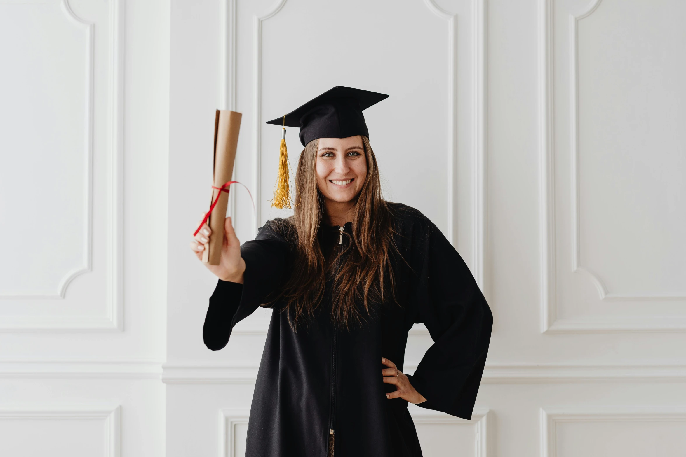 the female graduate is standing in her graduation gown