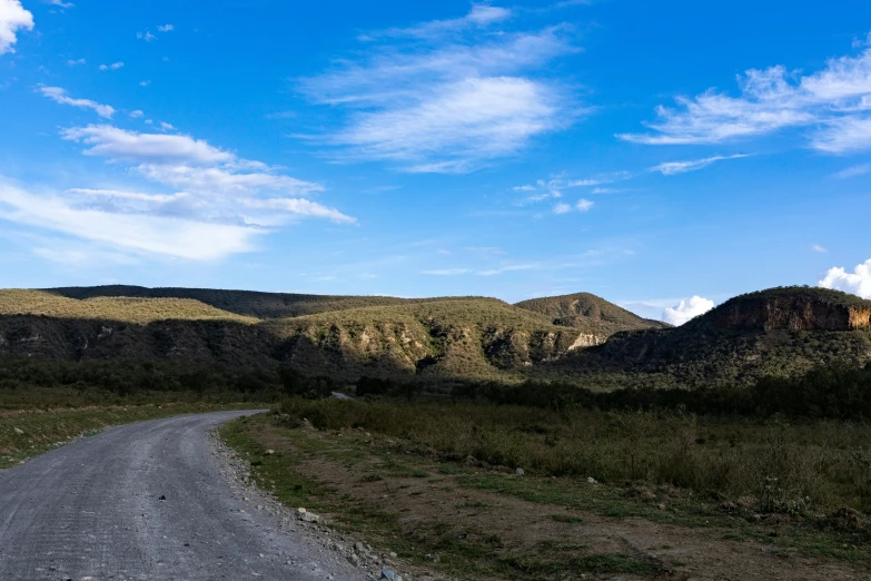 a road running through some grassy hills