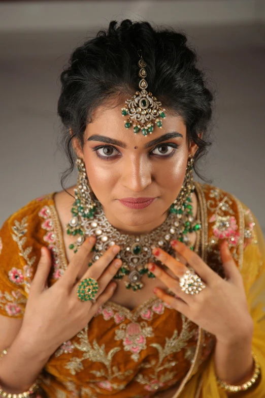 woman in traditional costume poses for pograph with necklaces and ear rings