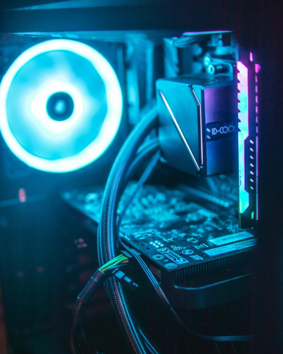 a dark room with a computer and some wires and a fan