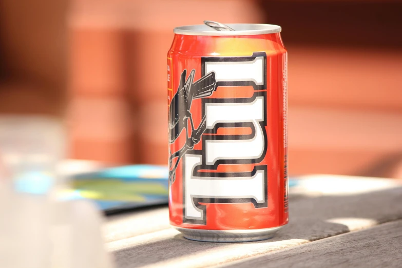 a can of beer sitting on top of a wooden table