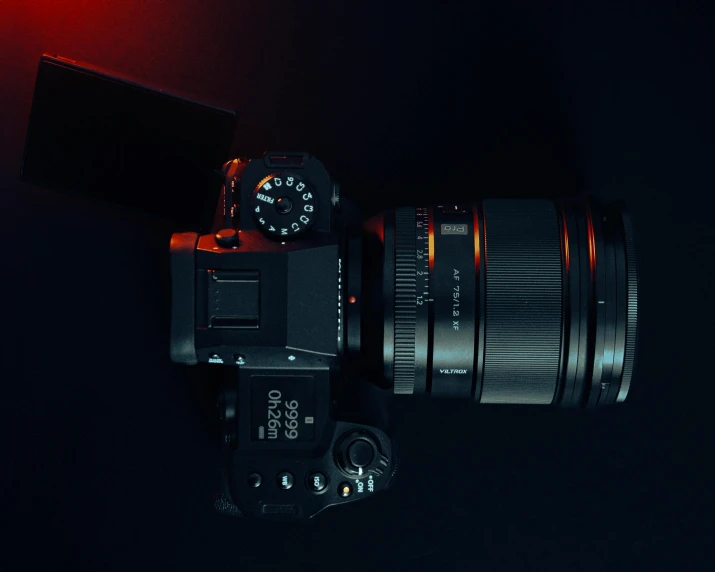 a black camera is shown against a red light