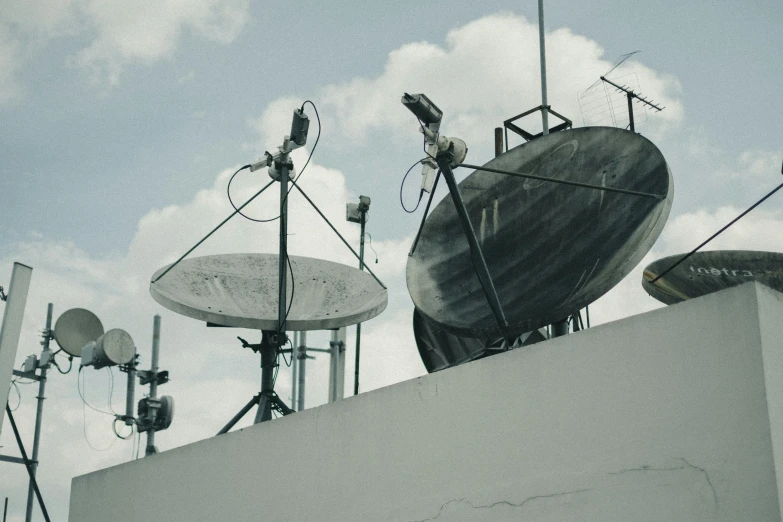 a group of tv antennas on top of a building