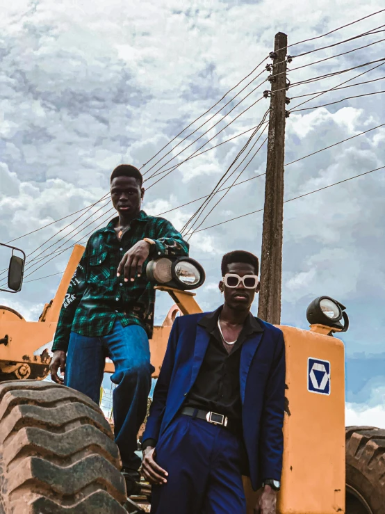 two men in front of tractor tire at rural area