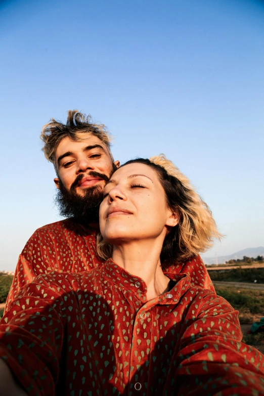 a man and woman smile and hold each other while looking up