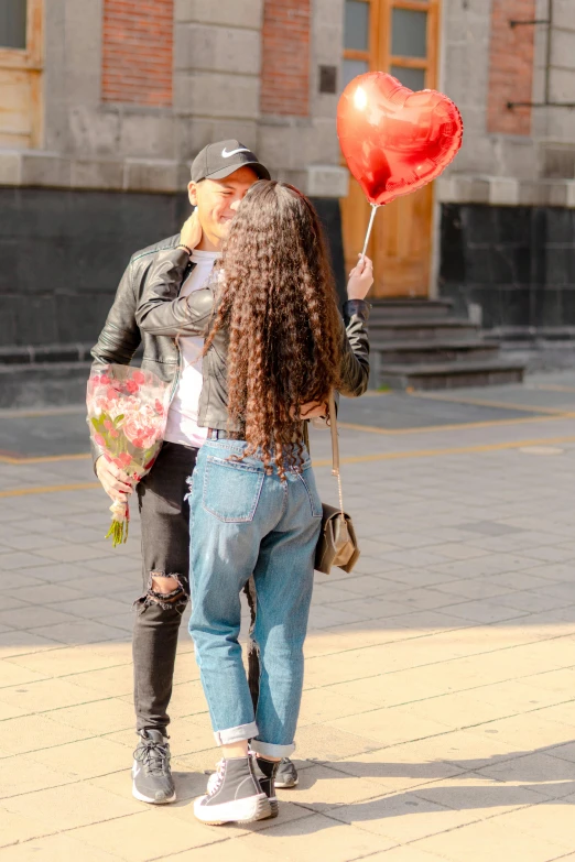 two women walking next to each other holding onto a balloon