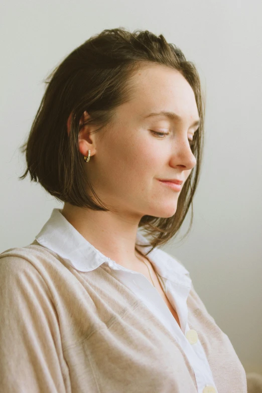 the woman has short brown hair and is looking into the distance