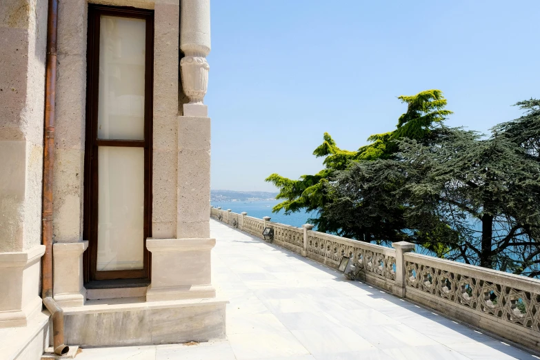 a stone walkway in front of an old building next to the water