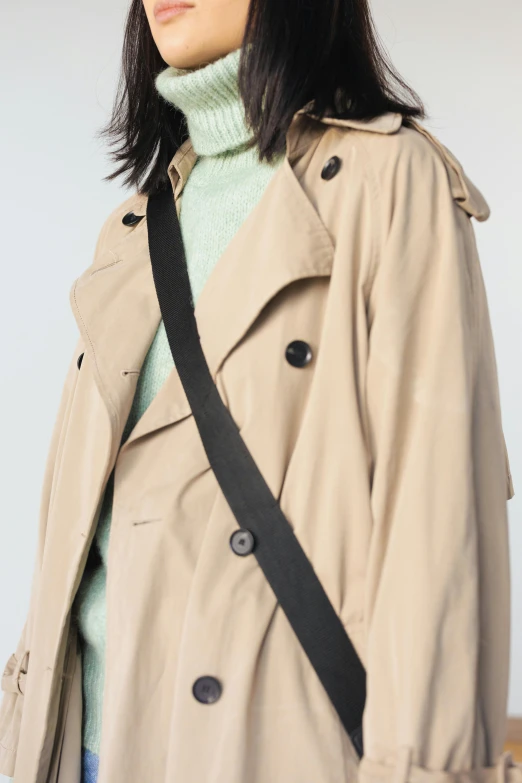 a women's trench coat with a black strap