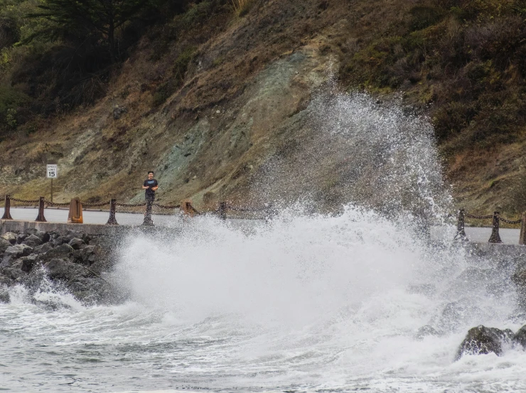 a large wave splashing on a road side