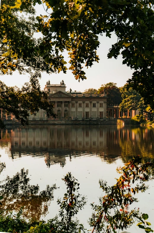 a palace sits on top of a lake surrounded by trees