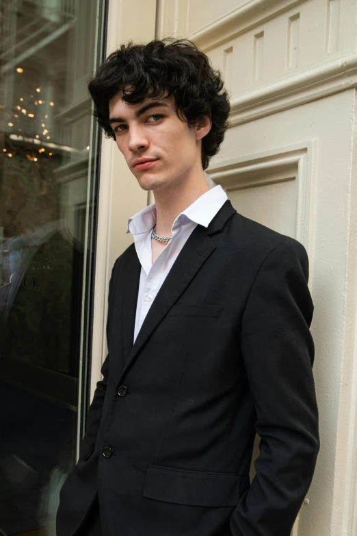 a man in a suit standing outside of a door