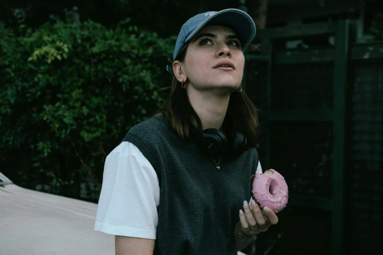 a woman holding a doughnut next to her face