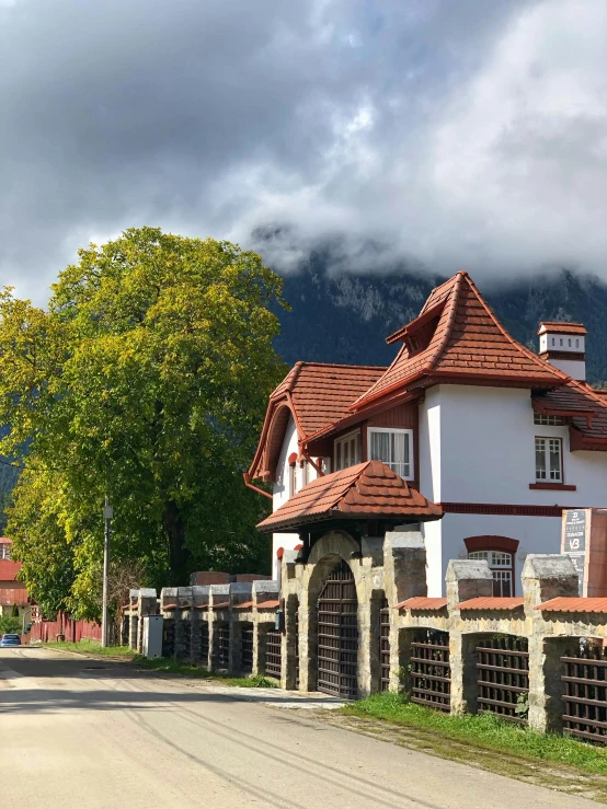 an old fashioned building with a wooden fence around it