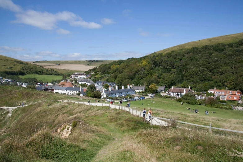 a scenic green hillside surrounded by small houses