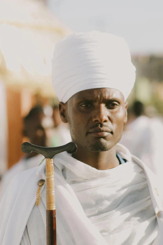 a person with a white turban is holding a pick ax