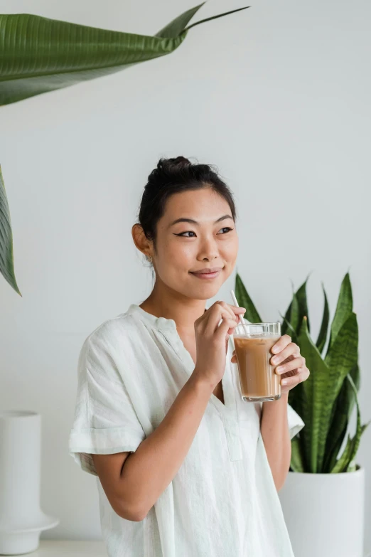 a woman is holding a glass with soing on it