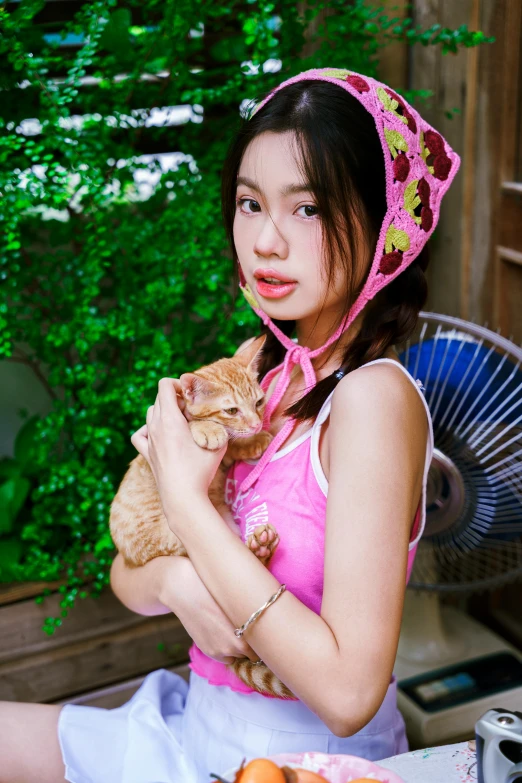 the woman is holding the kitten and posing for a picture