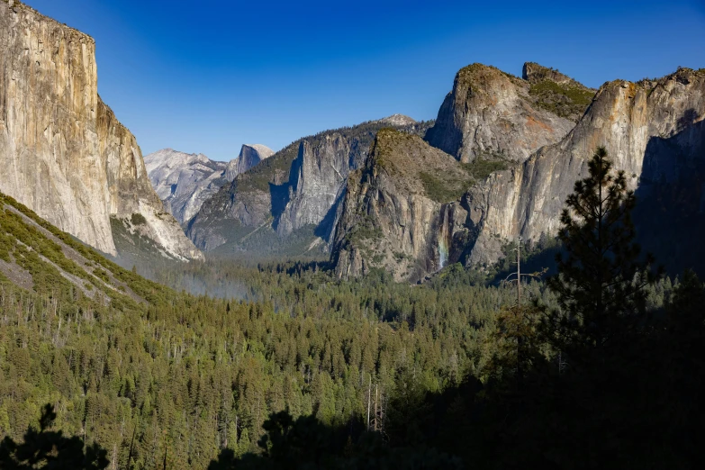 a view of mountains and trees on a sunny day