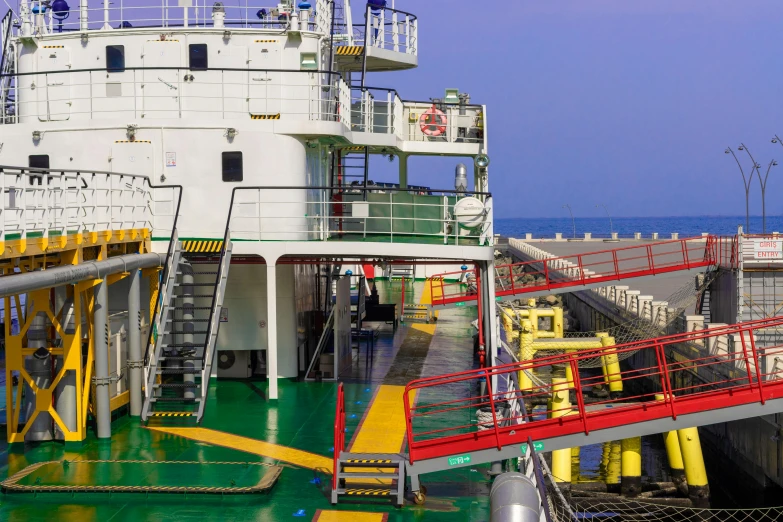 a large white ship with stairs and yellow rails