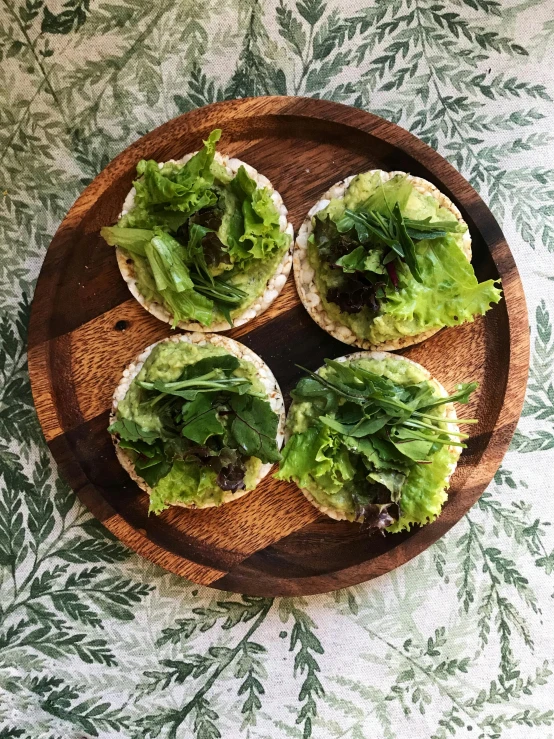 several pita breads filled with veggies on a wooden plate