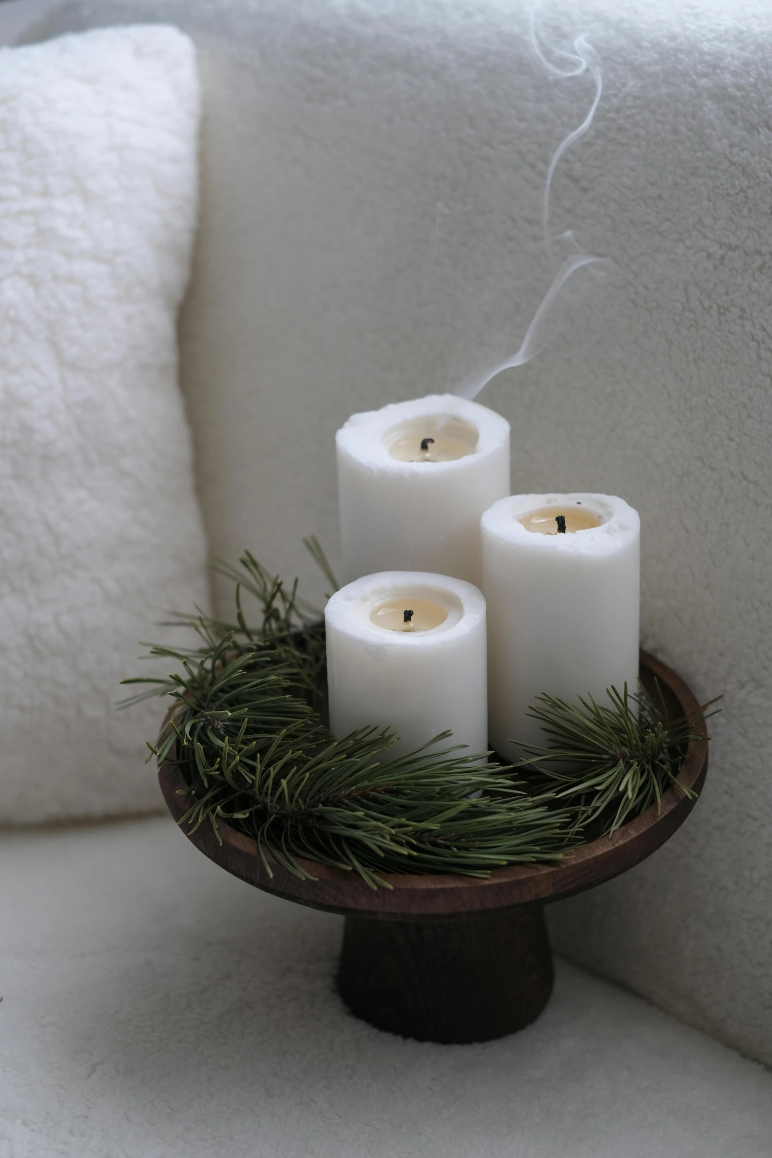 four candles lit in the middle of a small wooden tray