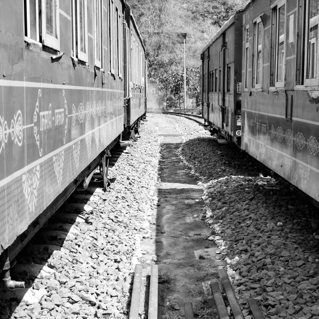 the train cars are side by side on tracks