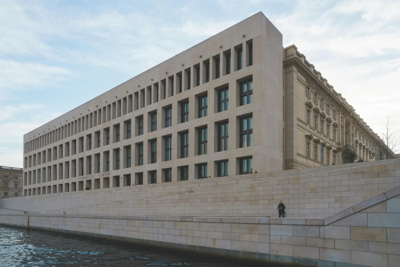 two people sitting on the bank near a building