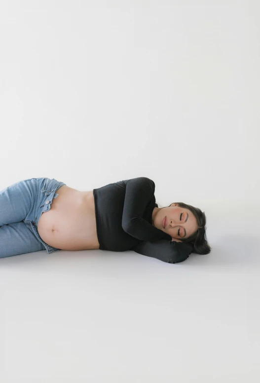 a woman laying on the ground and holding a banana