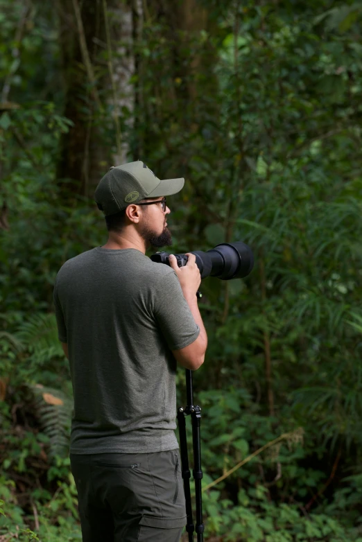 a man standing in the forest with a camera