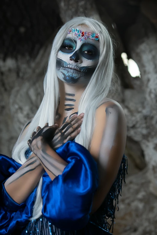 an individual with white hair and makeup dressed as a skeleton